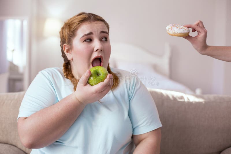 Mollige vrouw die aantrekkelijke appel eten royalty-vrije stock afbeelding Mollige vrouw die aantrekkelijke appel eten royalty-vrije stock afbeelding