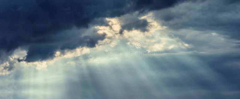 Molnig himmel för härlig mörk storm med strålar av solen som bryter till och med moln fotografering för bildbyråer