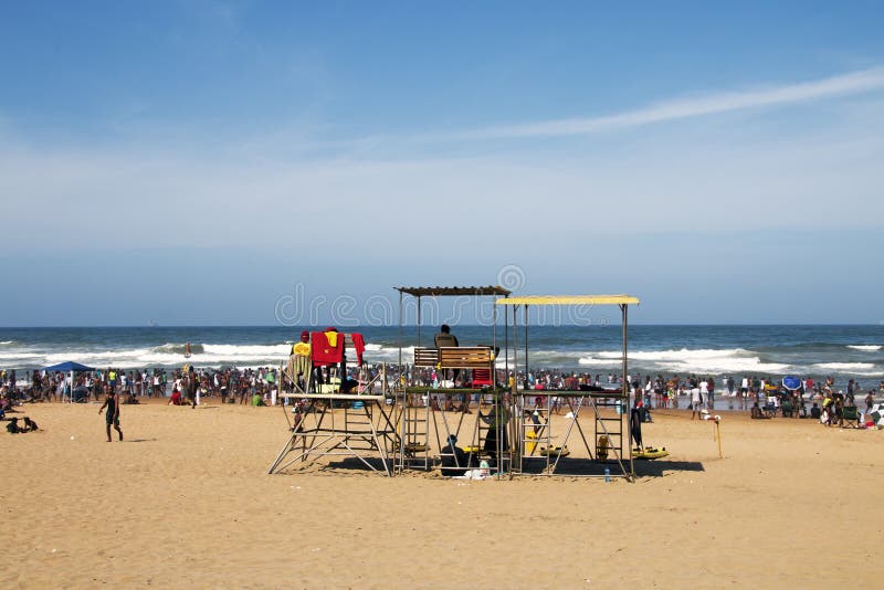 Molta gente sulla spiaggia contro l'oceano e l'orizzonte blu immagine stock libera da diritti Molta gente sulla spiaggia contro l'oceano e l'orizzonte blu immagine stock libera da diritti