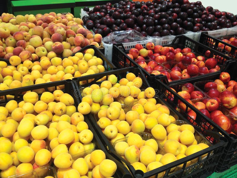 Molte albicocche, pesche, nettarine e prugne di frutti trovantesi nel supermercato delle scatole fotografia stock libera da diritti Molte albicocche, pesche, nettarine e prugne di frutti trovantesi nel supermercato delle scatole fotografia stock libera da diritti