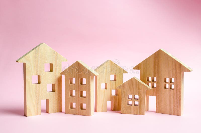 Molte case di legno su un fondo rosa Il concetto della città o della città Investendo nel bene immobile, comprante una casa gesti