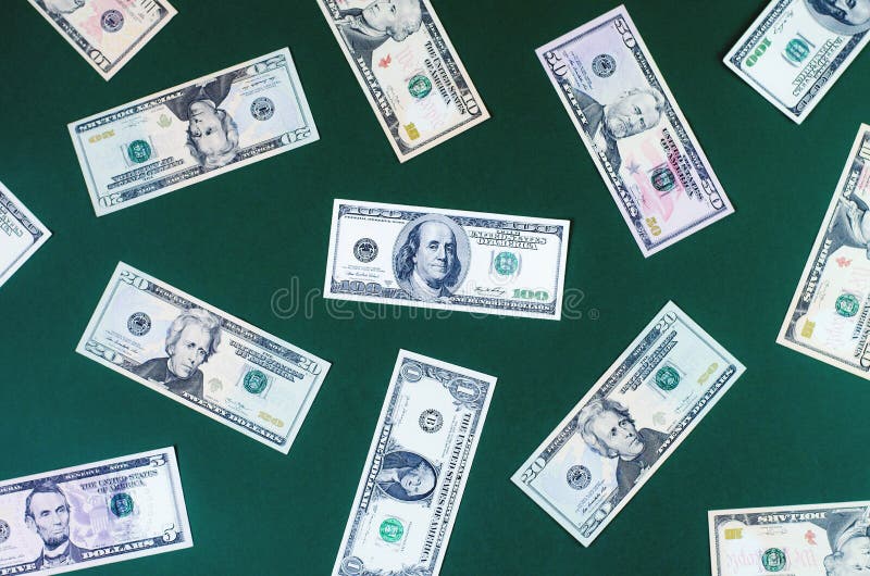 Molte fatture dei dollari delle denominazioni differenti su un fondo verde fotografie stock Molte fatture dei dollari delle denominazioni differenti su un fondo verde fotografie stock