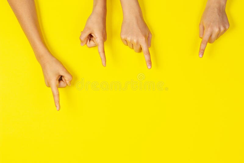 Molte mani puntano su qualcosa sullo sfondo giallo fotografie stock Molte mani puntano su qualcosa sullo sfondo giallo fotografie stock