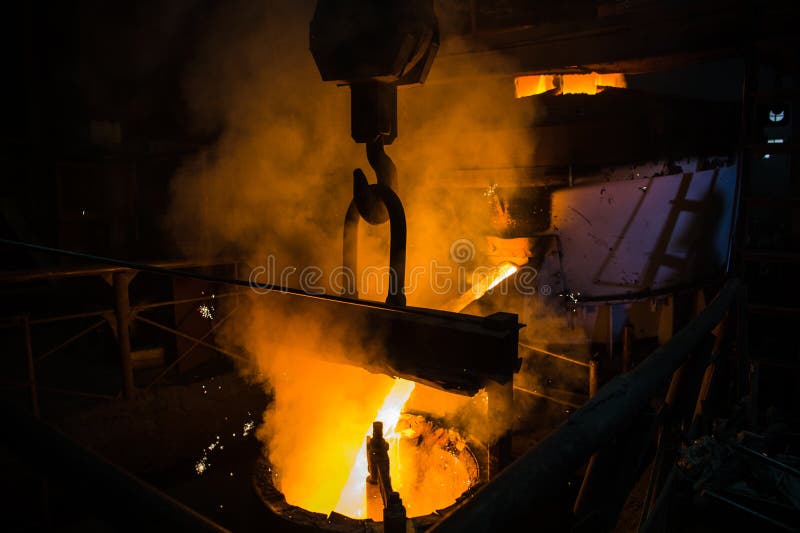 Molten steel pouring. Liquid hot metal of steel spills out of the ladle at steel factory. royalty free stock image Molten steel pouring. Liquid hot metal of steel spills out of the ladle at steel factory. royalty free stock image