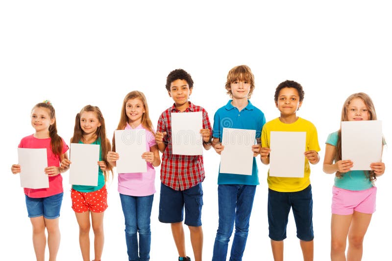 Molti bambini stanno con gli strati della carta in bianco nella linea immagine stock Molti bambini stanno con gli strati della carta in bianco nella linea immagine stock