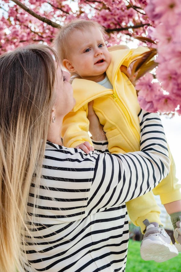 Mama și copilul se bucură de un minunat copac sakura primăvara. royalty free stock photo