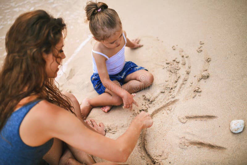 Mom and baby playing near beach. Traveling with family, child