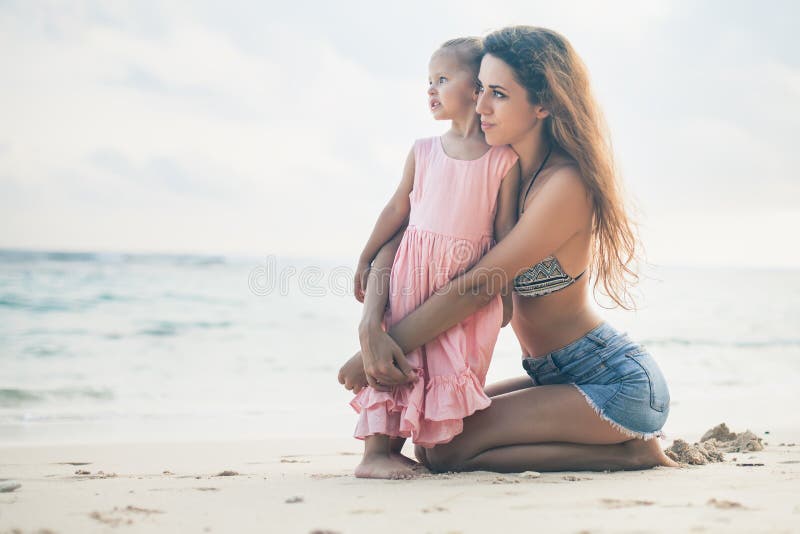 Mom and baby playing near beach. Traveling with family, child