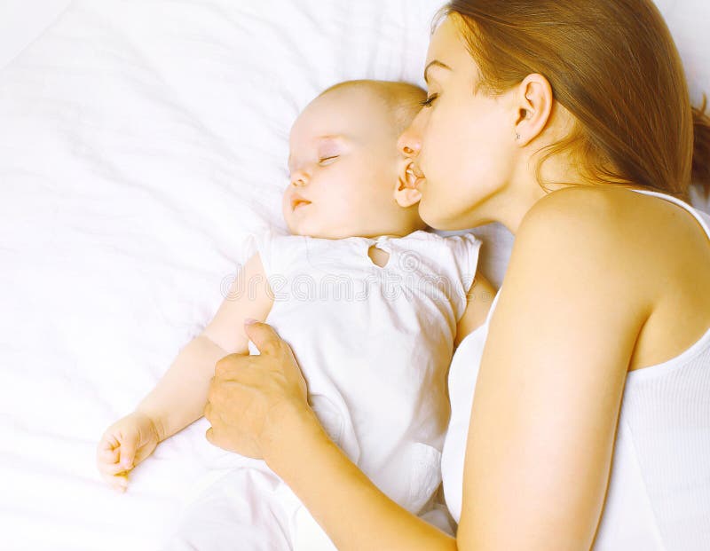 Madre a un nino durmiendo en una cama,, maternidad a armonía.