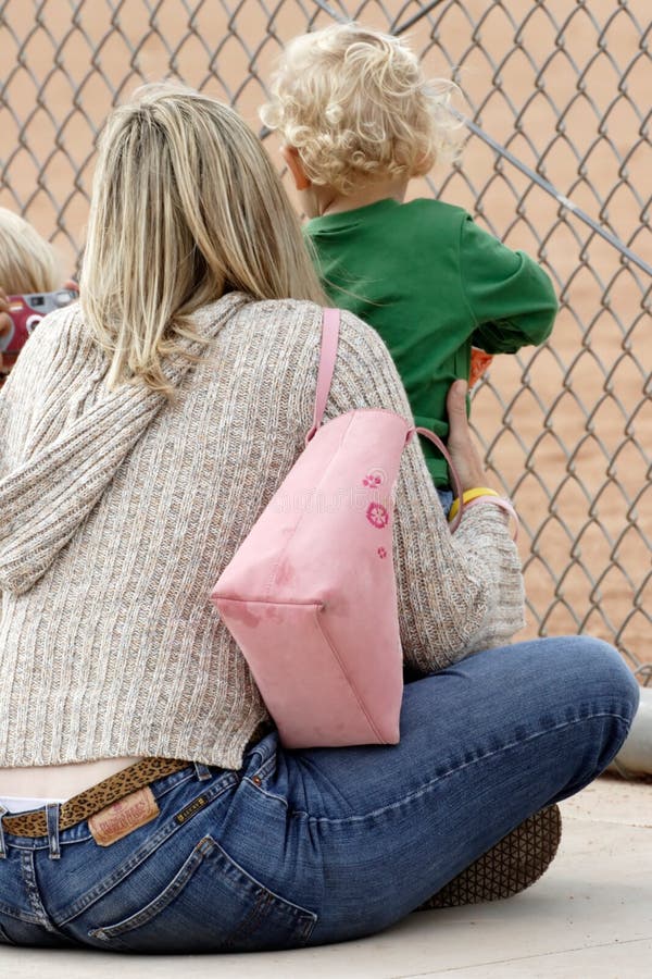 Mom and Baby watching baseball game on sidelines