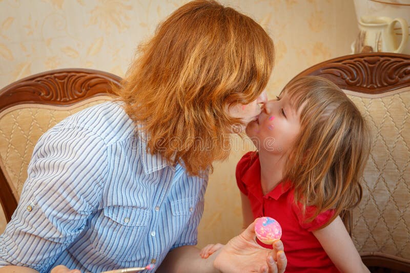 Mom and daughter have fun painting eggs for Easter stock photo Mom and daughter have fun painting eggs for Easter stock photo