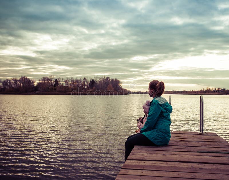 Mom and Daughter are Sitting on the Pier at Sunset Stock Photo - Image ...