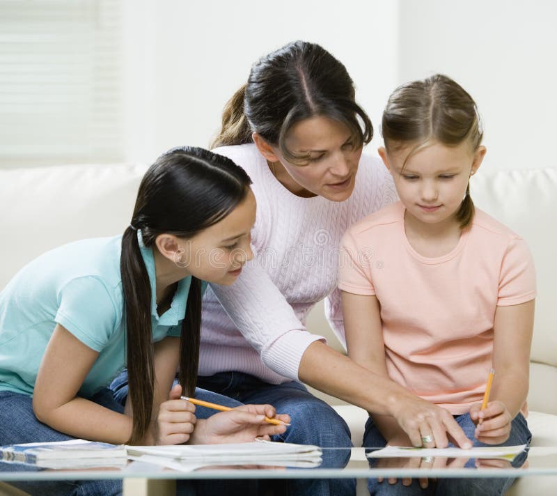 Mamma aiutare i bambini con i compiti sul tavolo.