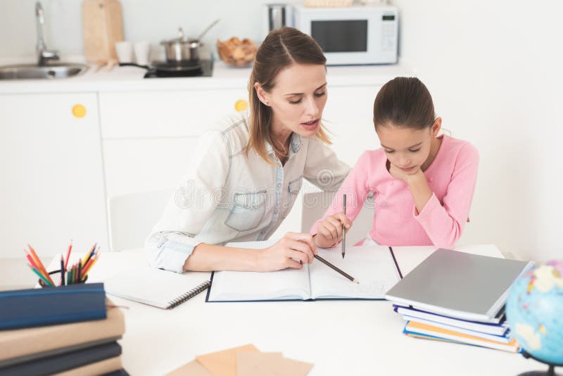 Mom Helps My Daughter Do Her Homework In The Kitchen Stock Image 