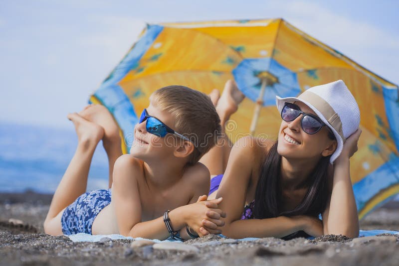 Mom and Son are Sunbathing on a Beach Stock Image - Image of ocean, vacation: 34207357