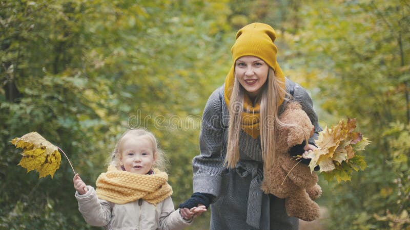 Mom spends time with her daughter - walks in autumn park and collect leaves, close up royalty free stock photo Mom spends time with her daughter - walks in autumn park and collect leaves, close up royalty free stock photo
