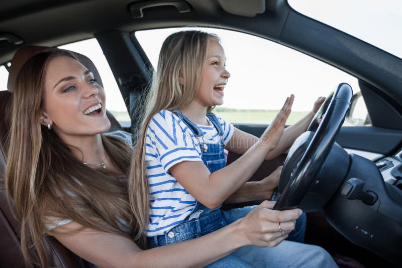 Mom teaches her little daughter to drive stock image Mom teaches her little daughter to drive stock image