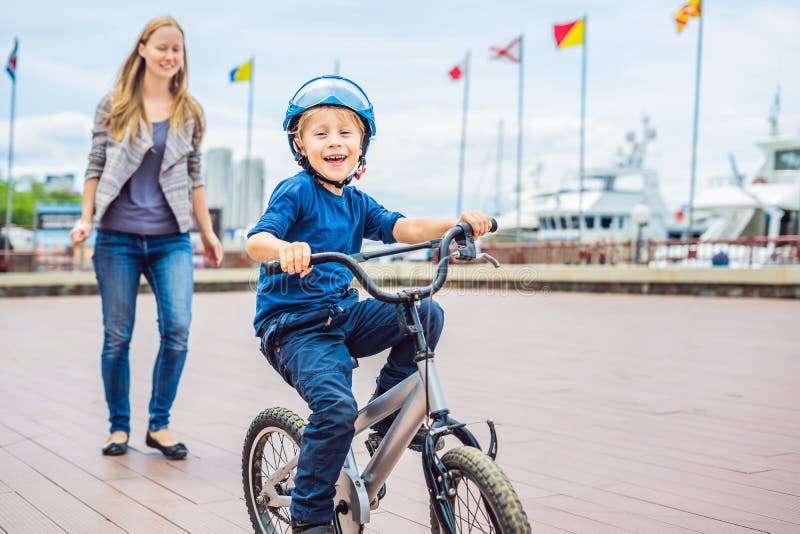Mom Teaches Son To Ride a Bike in the Park Stock Image photo