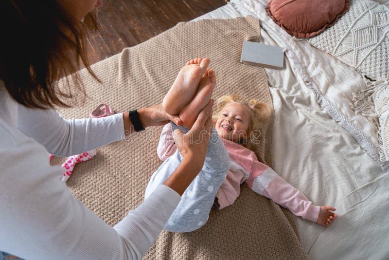 Mom Takes Off Her Little Daughter`s Socks And Tickles Her Feet A Little 680 