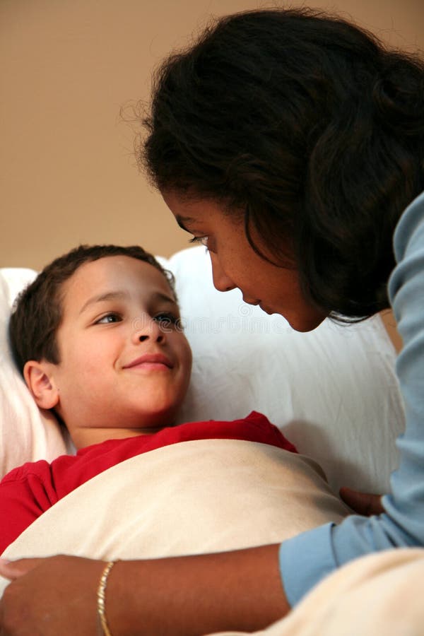 Mom Tucking Child into Bed stock image. Image of sleepy 1255313