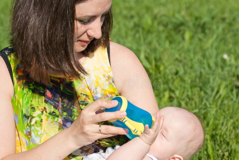 Mom waters the baby bottle stock photo. Image of eyes 16757026