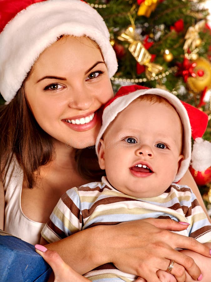 Mom wearing Santa hat holding baby son under