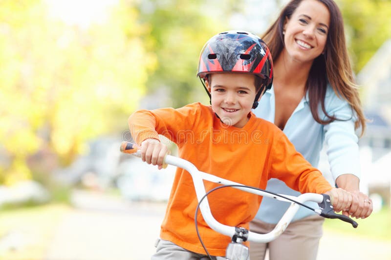 Mom Wont Let Him Fall A Young Mother Teaching Her Son How To Ride A Bicycle Stock Image