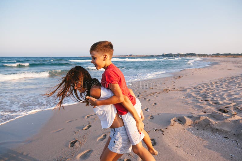 Mom and Son Walking and Playing on the Beach Stock Photo image