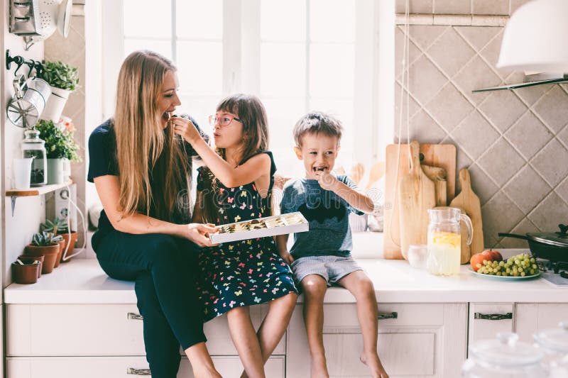 Mom με τα παιδιά που τρώνε στον πίνακα κουζινών στοκ εικόνα με δικαίωμα ελεύθερης χρήσης Mom με τα παιδιά που τρώνε στον πίνακα κουζινών στοκ εικόνα με δικαίωμα ελεύθερης χρήσης