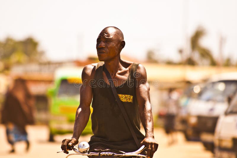 MOMBASSA, KENYA. DECEMBER 18, 2011: A lean Kenyan man rides his push bike through the streets of Mombassa, Kenya. MOMBASSA, KENYA. DECEMBER 18, 2011: A lean Kenyan man rides his push bike through the streets of Mombassa, Kenya.