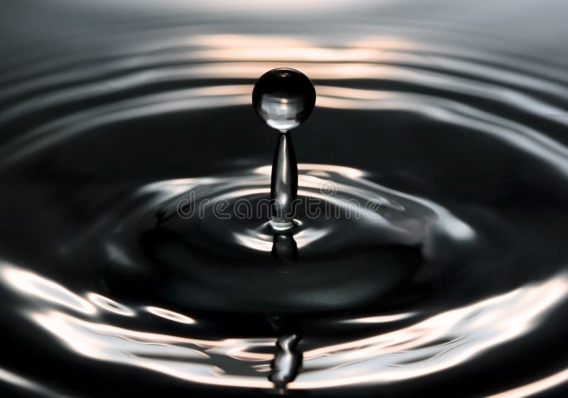 Close-up of a droplet splashing into water. Close-up of a droplet splashing into water.