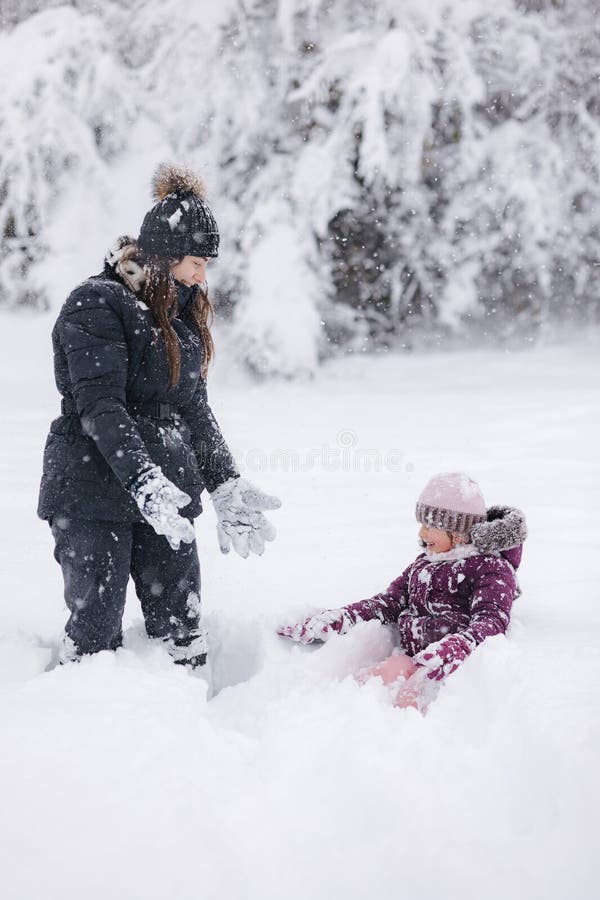 Moment réconfortant d'une mère et d'une fille qui jouent dans la neige capturant l'amour et les liens familiaux hivernaux photos libres de droits