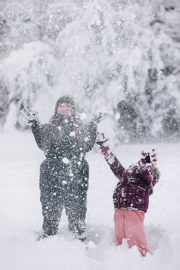 Moment réconfortant d'une mère et d'une fille qui jouent dans la neige capturant l'amour et les liens familiaux hivernaux photo stock