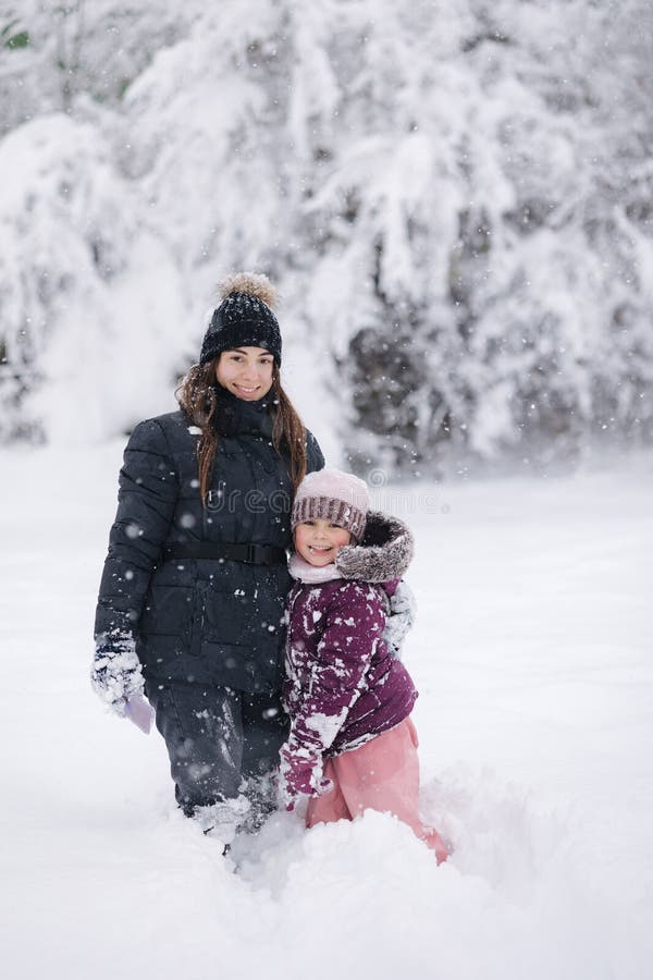 Moment réconfortant d'une mère et d'une fille qui jouent dans la neige capturant l'amour et les liens familiaux hivernaux photographie stock