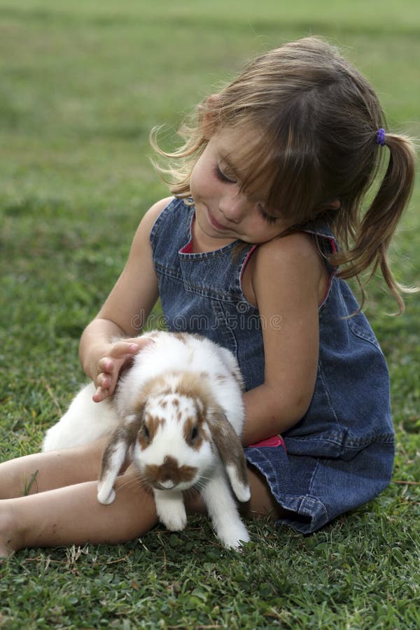 Young girl with pet rabbit in grass. Young girl with pet rabbit in grass