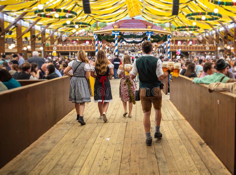 Monachium oktoberfest german Kelnera mienia piwa, namiotowy wewnętrzny tło zdjęcia royalty free Monachium oktoberfest german Kelnera mienia piwa, namiotowy wewnętrzny tło zdjęcia royalty free
