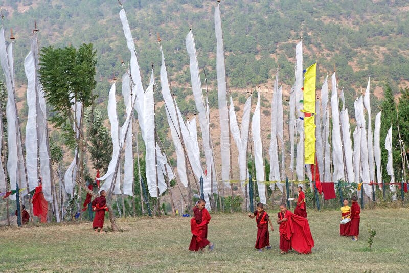 Monaci e bandiere di preghiera, Chimi Lhakang, Punakha, Bhutan immagini stock libere da diritti Monaci e bandiere di preghiera, Chimi Lhakang, Punakha, Bhutan immagini stock libere da diritti
