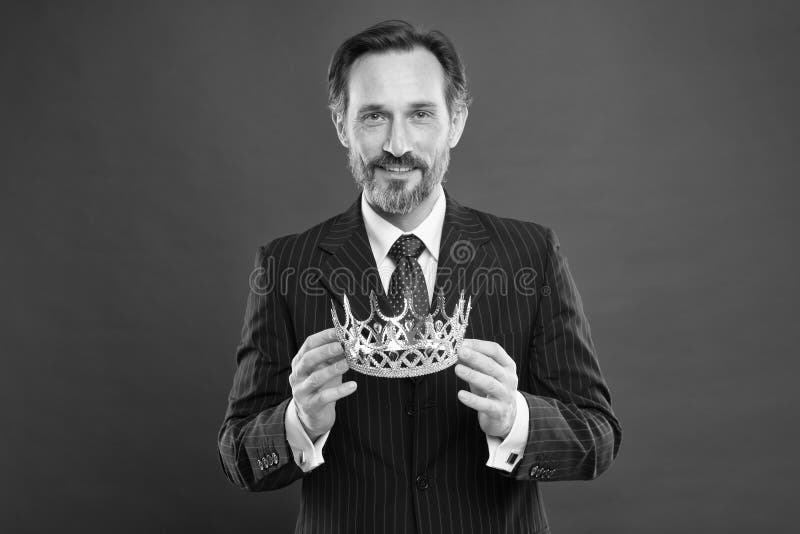 Monarchy attribute. Monarchy family traditions. Man bearded guy in suit hold golden crown symbol of monarchy. Become royalty free stock photo Monarchy attribute. Monarchy family traditions. Man bearded guy in suit hold golden crown symbol of monarchy. Become royalty free stock photo