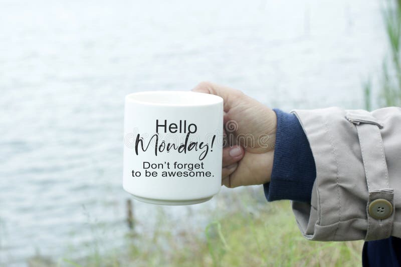 Monday inspirational quote - Hello Monday. Do not forget to be awesome. Person holding a cup of morning coffee in hand with text message on it. Monday motivational words concept. Monday inspirational quote - Hello Monday. Do not forget to be awesome. Person holding a cup of morning coffee in hand with text message on it. Monday motivational words concept