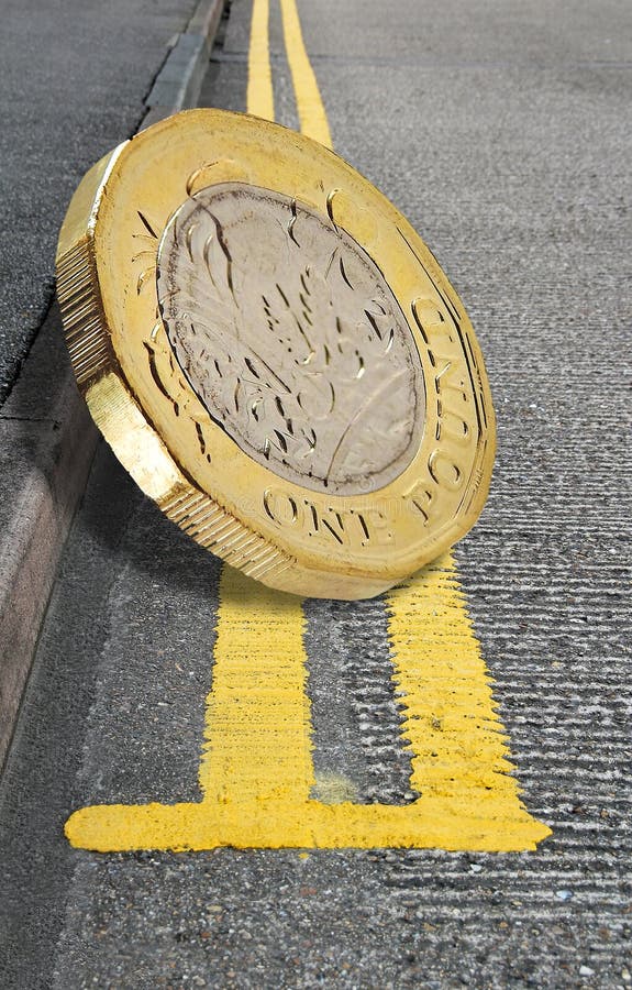 Moneda de libra británica en las líneas amarillas dobles aparcamiento