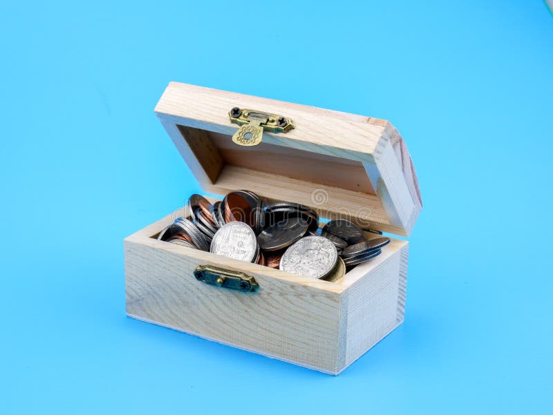 Moneda tailandesa en el pecho de madera en fondo azul imágenes de archivo libres de regalías Moneda tailandesa en el pecho de madera en fondo azul imágenes de archivo libres de regalías