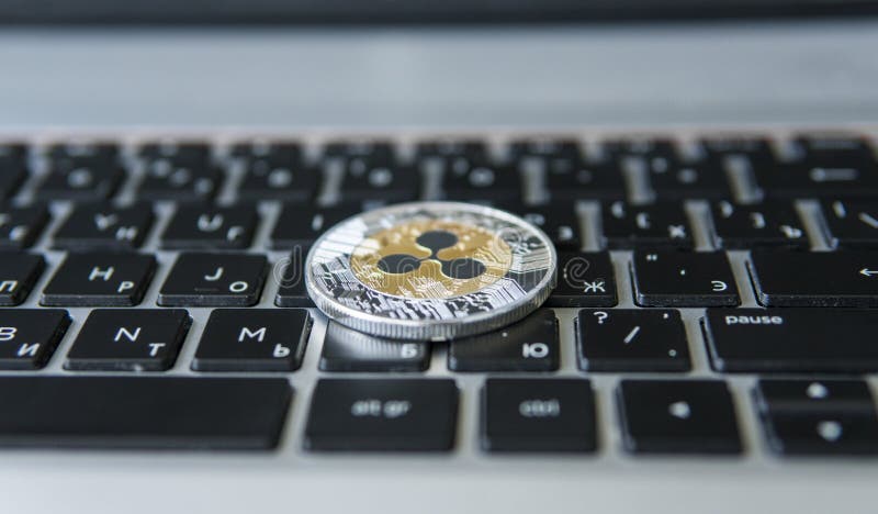 Moneta d'argento dell'ondulazione dell'oro su un primo piano della tastiera del computer portatile Estrazione mineraria di Blockc immagine stock
