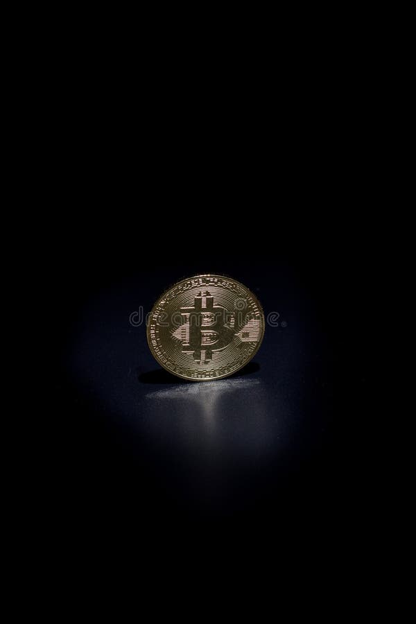Moneta da bitone d'oro su fondo nero fotografie stock