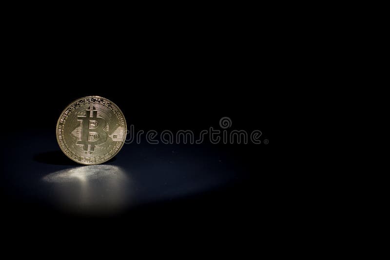 Moneta da bitone d'oro su fondo nero immagini stock