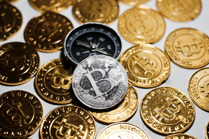 Moneta di Bitcoin vicino alla bussola immagini stock