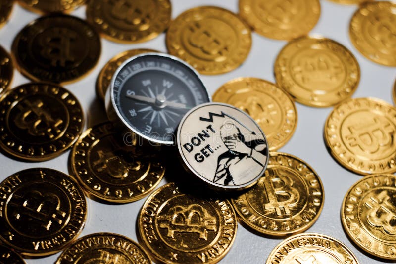 Moneta di Bitcoin vicino alla bussola fotografia stock