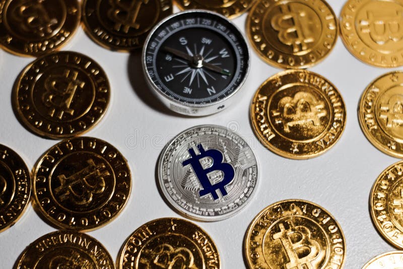 Moneta di Bitcoin vicino alla bussola immagini stock