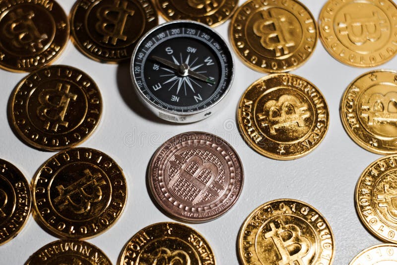 Moneta di Bitcoin vicino alla bussola immagine stock