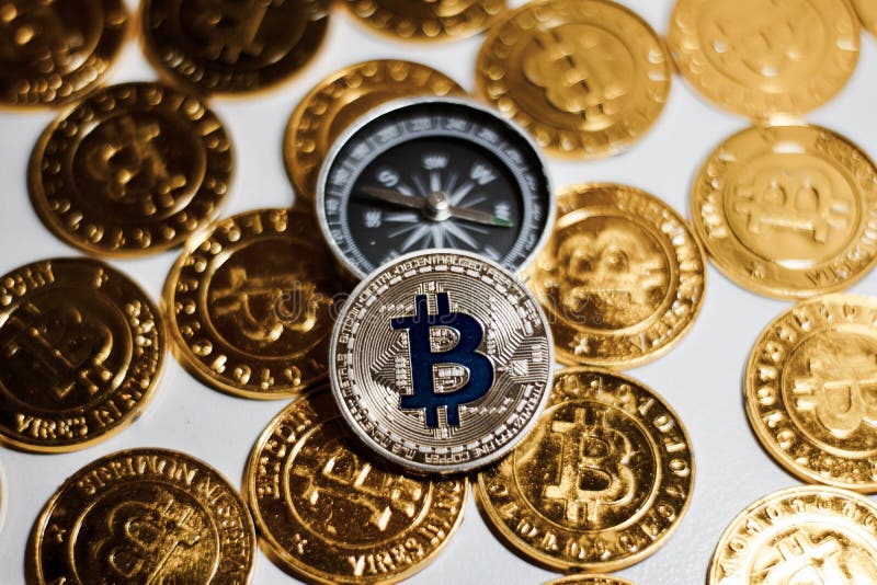Moneta di Bitcoin vicino alla bussola fotografie stock