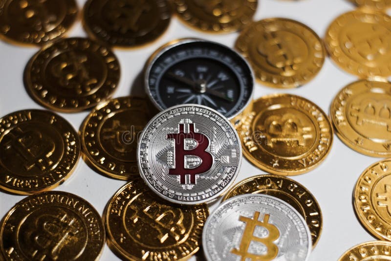 Moneta di Bitcoin vicino alla bussola immagini stock